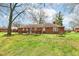 Brick home featuring a wooden deck and swing set surrounded by green grass at 5927 Pine Hill Dr, Indianapolis, IN 46235