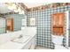Bathroom with classic plaid wallpaper, a white vanity, and traditional fixtures, offering a cozy space at 5927 Pine Hill Dr, Indianapolis, IN 46235