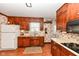 Traditional kitchen features wood cabinets, laminate counters, and floral wallpaper at 5927 Pine Hill Dr, Indianapolis, IN 46235