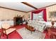 Bright living room with wood beam ceiling, vintage furniture, and striped wallpaper at 5927 Pine Hill Dr, Indianapolis, IN 46235