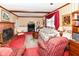 Living room with brick fireplace, wood beam ceiling, and vintage furniture at 5927 Pine Hill Dr, Indianapolis, IN 46235
