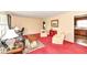 Comfortable living room with classic furnishings, leading to the kitchen area, with plush red carpeting at 5927 Pine Hill Dr, Indianapolis, IN 46235