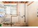Unfinished basement with exposed pipes, cinderblock walls, shelving, and a small window at 6017 E 52Nd Pl, Indianapolis, IN 46226