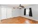 Well-lit bedroom with original hardwood floors, neutral walls, ceiling fan, and ample closet space at 6017 E 52Nd Pl, Indianapolis, IN 46226