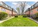 Charming brick townhomes surround a well-manicured grassy courtyard and mature landscaping at 6017 E 52Nd Pl, Indianapolis, IN 46226