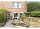 Attractive brick townhouse featuring a private entrance, stone wall, and decorative planters at 6017 E 52Nd Pl, Indianapolis, IN 46226