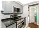 This kitchen features gray cabinets, black countertops, and stainless steel appliances at 6017 E 52Nd Pl, Indianapolis, IN 46226