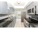 Traditional kitchen with gray cabinets, black countertops, stainless steel appliances, and white tile floors at 6017 E 52Nd Pl, Indianapolis, IN 46226