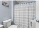 Cozy bathroom featuring a toilet and shower with striped curtain and decorative blue knobs at 621 Sonoma Ln, Greenfield, IN 46140