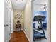 Hallway with hardwood floors and a doorway view of a fitness room with a treadmill at 621 Sonoma Ln, Greenfield, IN 46140