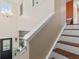 Hallway with hardwood floors leading to staircase with white railing and wood steps at 621 Sonoma Ln, Greenfield, IN 46140