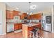 Well-lit kitchen featuring stainless steel appliances, wood cabinets, backsplash, island and two stools at 621 Sonoma Ln, Greenfield, IN 46140