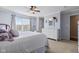 Bright main bedroom with a ceiling fan, a large window, and a view into the main bathroom at 621 Sonoma Ln, Greenfield, IN 46140