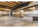 Unfinished basement with concrete floor, exposed ceiling, and wooden stairs ready for customization at 6408 Askin Dr, Indianapolis, IN 46259