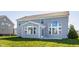 Back exterior of a two-story home with gray siding, a sunroom and large windows overlooking the yard at 6408 Askin Dr, Indianapolis, IN 46259