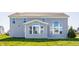 Back exterior of a two-story home with gray siding, a sunroom and large windows overlooking the yard at 6408 Askin Dr, Indianapolis, IN 46259