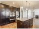 Spacious kitchen featuring stainless steel appliances, a granite island, and dark cabinetry at 6408 Askin Dr, Indianapolis, IN 46259