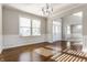 Inviting living room boasts hardwood floors, a modern chandelier, and large windows for natural light at 6408 Askin Dr, Indianapolis, IN 46259