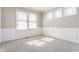 Bright living room showcasing three windows, neutral walls, and decorative wainscotting at 6408 Askin Dr, Indianapolis, IN 46259