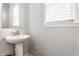 Clean powder room featuring a pedestal sink, framed mirror, and white trim at 6408 Askin Dr, Indianapolis, IN 46259