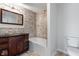 Stylish bathroom with a dark wood vanity, stone-look tiled shower, and modern fixtures for a spa-like retreat at 6519 Rothchild Blvd, Indianapolis, IN 46278