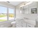 Bright bathroom with a granite-topped vanity, sleek mirror, and large window offering a scenic view at 6519 Rothchild Blvd, Indianapolis, IN 46278