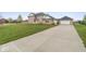 Brick house with large driveway, landscaped yard and attached garage at 6519 Rothchild Blvd, Indianapolis, IN 46278