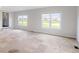 Spacious living room featuring stone tile flooring, large windows, and bright, neutral-colored walls at 6519 Rothchild Blvd, Indianapolis, IN 46278