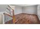 Second-floor landing featuring hardwood floors, staircase with iron spindles, and lots of natural light at 6519 Rothchild Blvd, Indianapolis, IN 46278