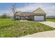 Well maintained brick home with attached garage and manicured lawn with lovely walkway leading to the front door at 6606 Colt Ln, Anderson, IN 46013