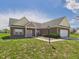 Charming brick home with an attached garage, lovely landscaping, and a well-manicured lawn on a beautiful day at 6606 Colt Ln, Anderson, IN 46013