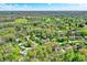 Aerial view showcases a neighborhood surrounded by lush trees and a nearby golf course at 70 Williamsburg Ct, Zionsville, IN 46077