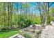 Backyard features a fire pit area and landscaping, set against a wooded backdrop at 70 Williamsburg Ct, Zionsville, IN 46077