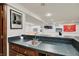Finished basement bar area with dark countertops, chrome faucet, and sports decor for entertaining at 70 Williamsburg Ct, Zionsville, IN 46077