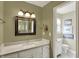 Bathroom with white marble countertop and view of the toilet in separate room at 70 Williamsburg Ct, Zionsville, IN 46077