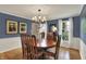 Traditional dining room featuring hardwood floors, blue walls, and a decorative chandelier at 70 Williamsburg Ct, Zionsville, IN 46077