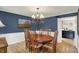 Cozy dining room with hardwood floors, wainscoting, and a view into kitchen at 70 Williamsburg Ct, Zionsville, IN 46077