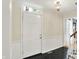 Elegant foyer with dark tile flooring, white trim, and a classic lighting fixture at 70 Williamsburg Ct, Zionsville, IN 46077