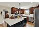 Well-lit kitchen boasts stainless appliances, a large island with a white countertop and dark cabinets, plus pendant lighting at 70 Williamsburg Ct, Zionsville, IN 46077