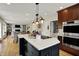 Open concept kitchen features stainless appliances, a large island, and connects to a living area with built-in shelves at 70 Williamsburg Ct, Zionsville, IN 46077