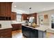 Well-lit kitchen features wood floors, white subway tile backsplash, stainless appliances, and a large island with cooktop at 70 Williamsburg Ct, Zionsville, IN 46077