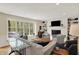 Spacious living room with a large window, fireplace, built-in shelves, and recessed lighting at 70 Williamsburg Ct, Zionsville, IN 46077