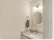 Elegant half bathroom features a round mirror, vanity, and modern fixtures at 70 Williamsburg Ct, Zionsville, IN 46077