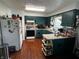 Functional kitchen features dark-colored cabinetry, laminate floor, and matching island at 712 E Mckenzie Rd, Greenfield, IN 46140