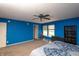 Blue bedroom with ceiling fan, bed, chair and view of the outdoors at 717 Driftwood Cir, Danville, IN 46122