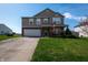 Charming two-story home features a manicured lawn and a welcoming front porch with an American flag displayed at 717 Driftwood Cir, Danville, IN 46122