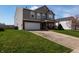 View of the charming two-story home featuring well-maintained landscaping and a spacious two car garage at 717 Driftwood Cir, Danville, IN 46122