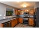 Modern kitchen features stainless steel appliances, wood cabinets, and an open layout, perfect for cooking at 717 Driftwood Cir, Danville, IN 46122
