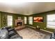 Living room with stone fireplace, mounted flat screen tv, and comfortable leather seating at 717 Driftwood Cir, Danville, IN 46122