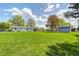 Spacious backyard with mature trees and green grass leads to a shed, creating a private outdoor oasis at 7170 Janean Dr, Brownsburg, IN 46112
